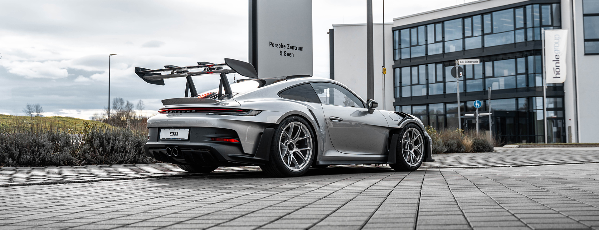 Ein Porsche Sportwagen steht vor dem Porsche Zentrum 5 Seen.